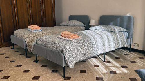 2 letti con asciugamani sopra in una stanza di Villa Teresina Noli a Noli