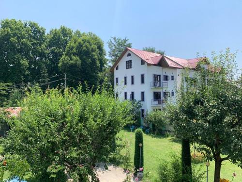 ein großes weißes Haus mit einem Hof mit Bäumen in der Unterkunft NIGEEN RESORT in Srinagar