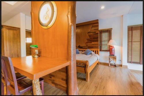 Ban Nong Pa Kha的住宿－บ้านสวนภูรจิตร Baansuanphurajit，一间卧室配有一张床、一张桌子和闹钟