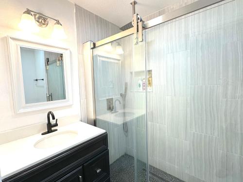 uma casa de banho com um lavatório e uma cabina de duche em vidro. em Cozy UCI Townhome 2 Bedroom 2 Bath em Irvine