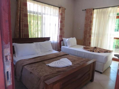 um quarto com 2 camas e toalhas em MIKUMI RESORT HOTEL em Mikumi
