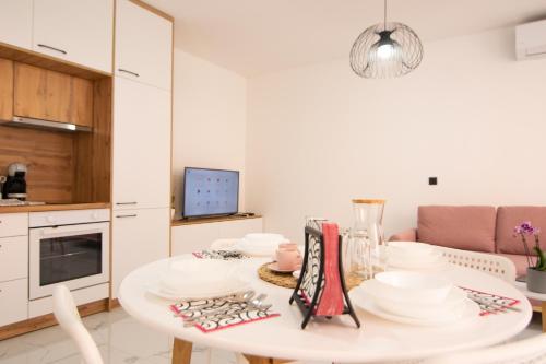 eine weiße Küche mit einem Tisch mit Tellern darauf in der Unterkunft S&B Apartment in Koper
