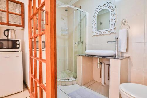 y baño con ducha y lavamanos. en Snooze-A-Lot Guesthouse, en Secunda