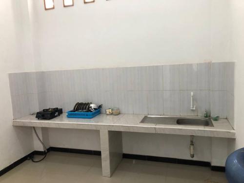 a kitchen counter top with a sink and a counter at Jasmine Homestay Syariah in Jepara