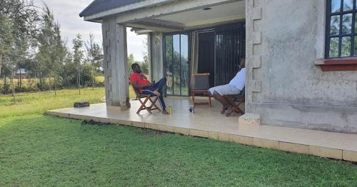 dos personas sentadas en el porche de una casa en Nyakach Getaway Kisumu, en Kap Sarok