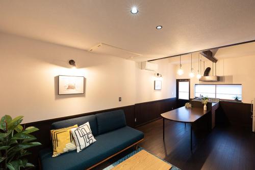 城崎温泉一棟貸し　旅宿YaDOKARI في تويوكا: غرفة معيشة مع أريكة وطاولة