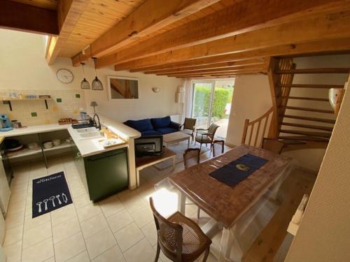 une cuisine et un salon avec une table et des chaises dans l'établissement le Domaine du Petit Bois, Gîte le Marronnier, à Varzay