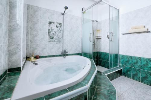 a bathroom with a tub and a glass shower at Villa Chloe in Ayia Napa