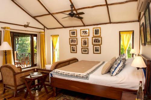 a bedroom with a bed and a table and a window at Jim's Jungle Retreat in Rāmnagar