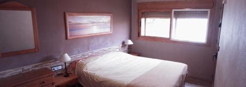 ein kleines Schlafzimmer mit einem Bett und zwei Fenstern in der Unterkunft Apartamento con varias piscinas, jardines y garaje en Costa Hispania in Gran Alacant