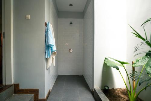a bathroom with a shower with a towel on the wall at Manta Dive Gili Trawangan Resort in Gili Trawangan