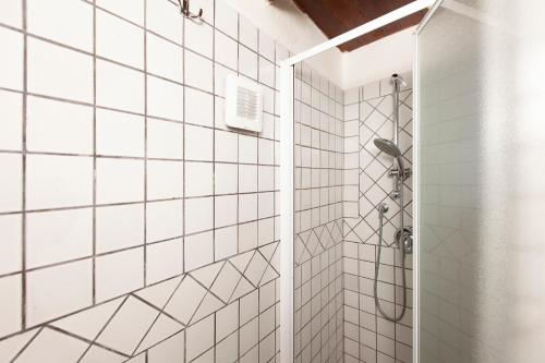 uma casa de banho com um chuveiro com paredes em azulejos brancos em Loft Antica Cagliari em Cagliari