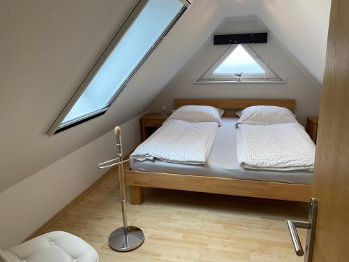 1 dormitorio en el ático con 2 camas y 2 ventanas en Ferienhaus Grawwert, en Polchow