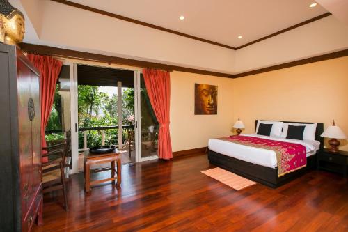 a bedroom with a bed and a large window at Katamanda villa Sooksan Near Kata Noi Beach in Kata Beach