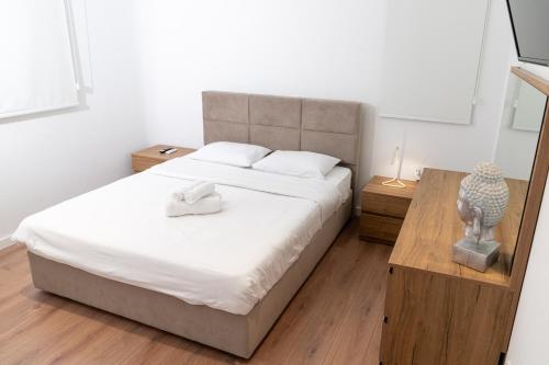 Un dormitorio con una cama grande con sábanas blancas. en Venus Apartment, en Lárnaca