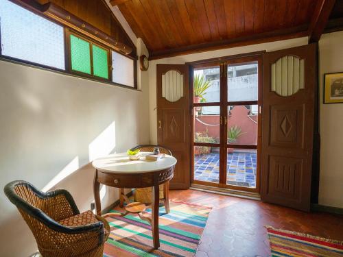a room with a table and chairs and a door at The House of MG-A Heritage Hotel, Ahmedabad in Ahmedabad