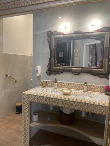 a bathroom with a sink and a mirror at Suite Orientale Maison de L'église du Couvent in Narbonne