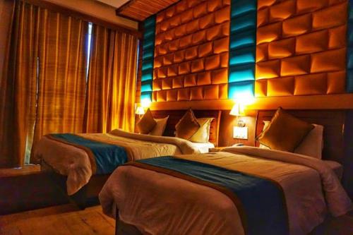 En eller flere senge i et værelse på Hotel Joshimath Inn