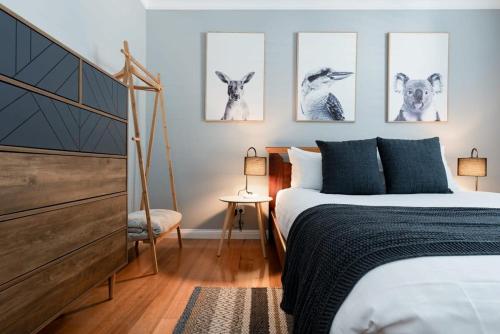 a bedroom with four drawings of llamas on the wall at Balfour Cottage WiFi & Parking in Launceston