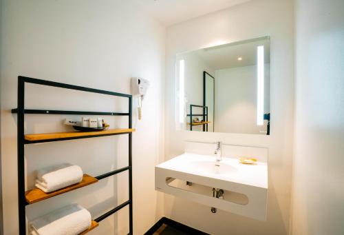 a bathroom with a sink and a mirror at ONOMO Hotel Kampala in Kampala