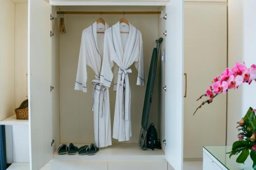 a wardrobe with white clothes and shoes at Jaya Suites Hotel in Phnom Penh
