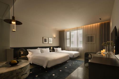 成都市にあるTableroundのベッド2台とテーブルが備わるホテルルームです。