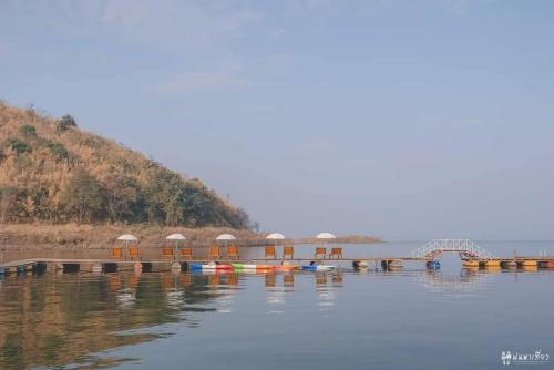 a dock with a group of boats on the water at ภูไพรเลค รีสอร์ท in Ban Wang Khun Knachen