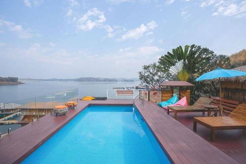 a swimming pool on a deck with a view of the water at ภูไพรเลค รีสอร์ท in Ban Wang Khun Knachen