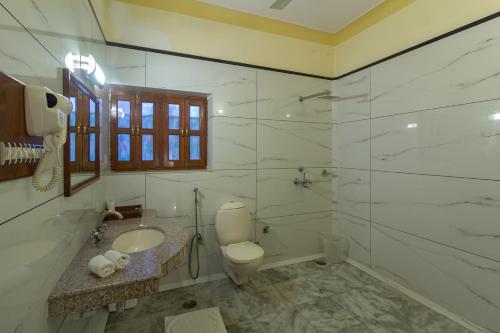 W łazience znajduje się toaleta, umywalka i lustro. w obiekcie Polo Heritage Hotel w mieście Dźodhpur