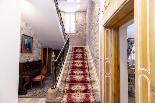 a set of stairs with red carpeting in a building at Suite Royale Maison de l'église du couvent in Narbonne