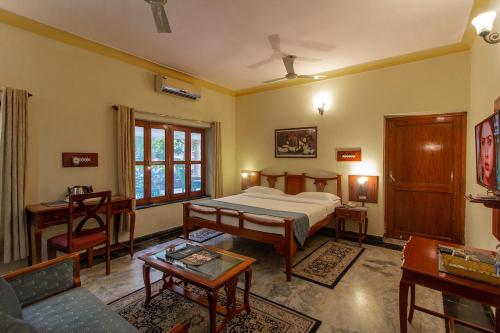 Polo Heritage Hotel في جودبور: غرفة نوم مع سرير وغرفة معيشة