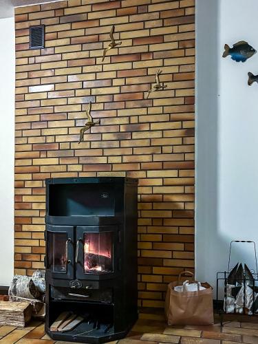 a fireplace in a room with a brick wall at W Ogrodzie Dla Gości in Sasino