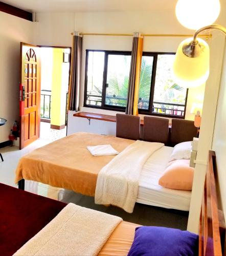 a bedroom with a large bed and windows at Moalboal Seaside Resort in Moalboal