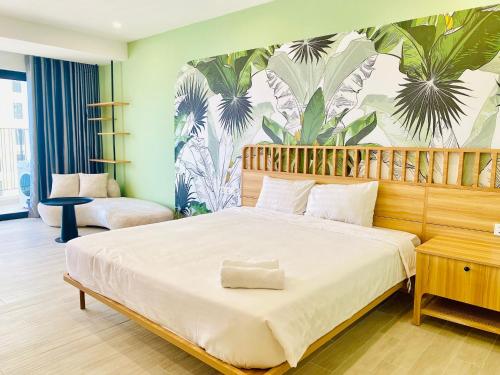 a bedroom with a large bed with a tropical wallpaper at Cozy GoldCoast Apartment in Nha Trang