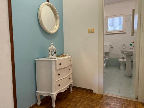 a bathroom with a white dresser and a mirror at Villa Bucchi in Lido di Spina