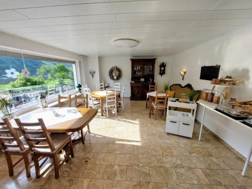 a kitchen and dining room with a table and chairs at Pension Mosella, Gästezimmer in Sankt Aldegund