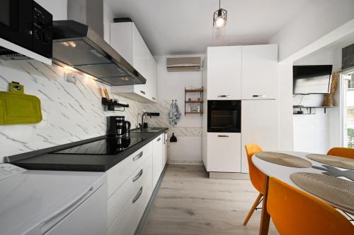 a kitchen with white cabinets and a black counter top at AP Silvija in Zadar
