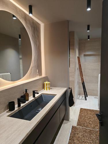 a bathroom with a sink and a mirror at Maison Gaia Seychelles, unobstructed views over the ocean and into the sunset in Glacis
