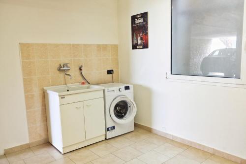 a laundry room with a washing machine and a window at Casa Aaron in Tremosine Sul Garda