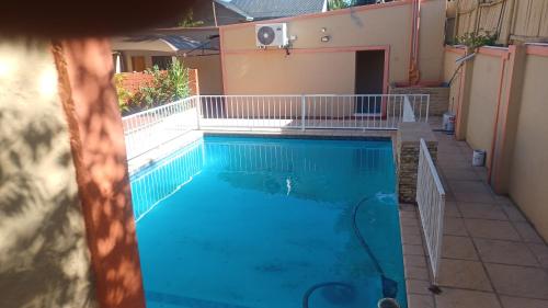 a swimming pool with blue water in a building at De'moore Guest House in Johannesburg
