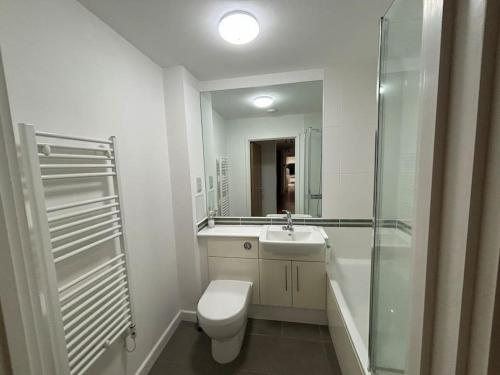 a bathroom with a toilet and a sink and a shower at Lovely 3 bedroom penthouse apartment near Heathrow in West Drayton