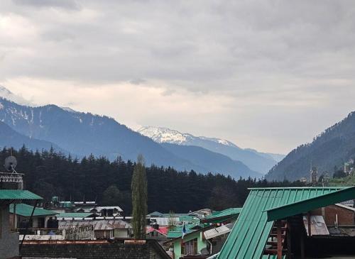 a view of a town with mountains in the background at Hotel Premier Mall Road Manali in Manāli