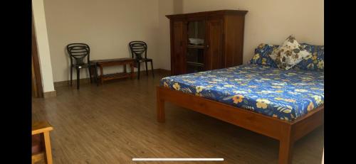 a bedroom with a bed and chairs in it at Tenam Garden homestay in Kalimpong
