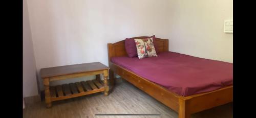 a small bedroom with a bed and a table at Tenam Garden homestay in Kalimpong