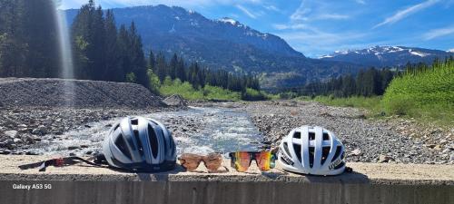 three people wearing helmets sitting on a wall next to a river at Ferienhaus Waldhof in Hermagor