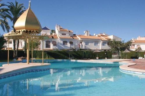 ein Schwimmbad vor einem großen Haus in der Unterkunft Apartamento con varias piscinas, jardines y garaje en Costa Hispania in Gran Alacant