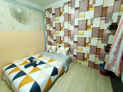 a bedroom with a bed with a wall made of squares at Kota 3BR Townhouse 5 Pax - TVBox/Mahjong/Jonker in Melaka