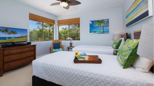 a bedroom with two beds and a flat screen tv at HAWAIIANA ESCAPE Tropical 3BR Kulalani Home with Bikes and Beach Club in Waikoloa