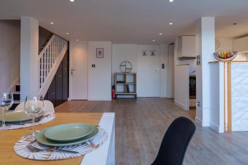a dining room and living room with a table and chairs at Le Loft D'Oc - Duplex 117m2 - 2 chambres et jardin in Launaguet
