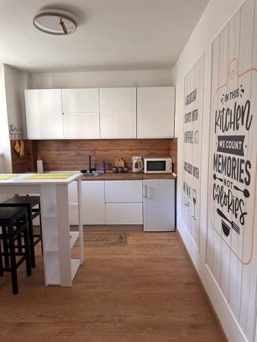 a kitchen with white cabinets and a table at Darius in Tuzla